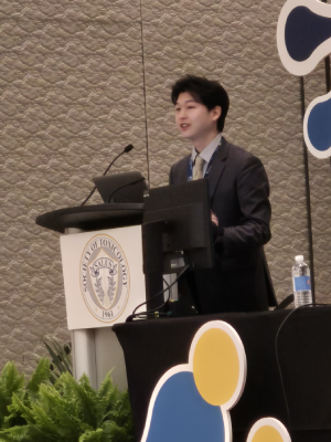Joe Lim stands at a podium speaking.